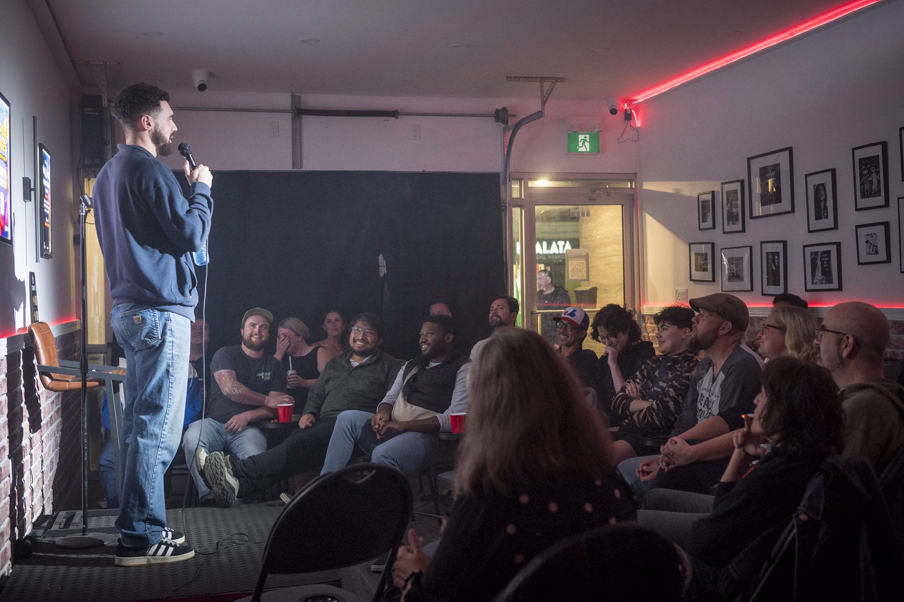 Comedian performing to a packed room at The Boardroom Comedy Club