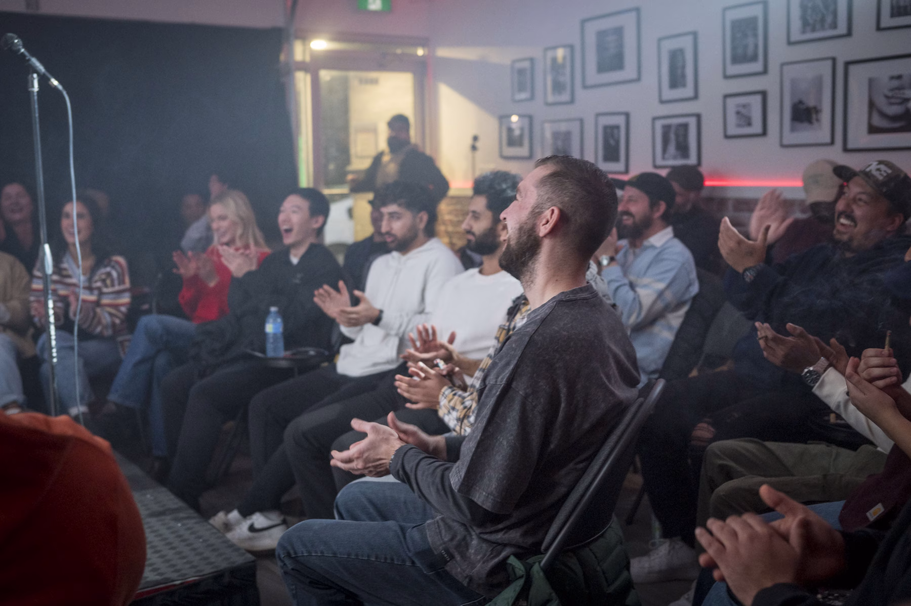 Audience clapping and laughing during a comedy show at The Boardroom